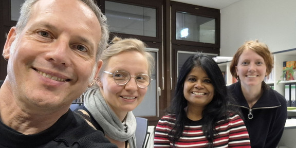 Selfie von Cornelius Schubert, Julia Kurz, Tannistha Samanta und Isabelle Bosbach im Büro. Alle lächeln in die Kamera